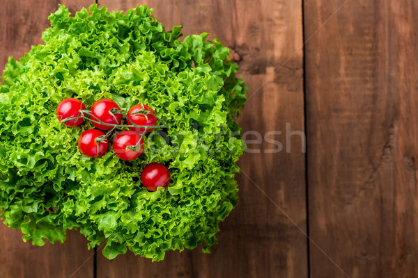 Stock photo: lettuce salad and cherry tomatoes on a wood background