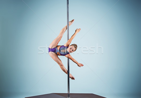 The strong and graceful young girl performing acrobatic exercises on pylon Stock photo © master1305