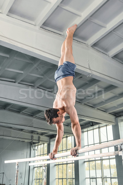 Male gymnast performing handstand on parallel bars Stock photo © master1305