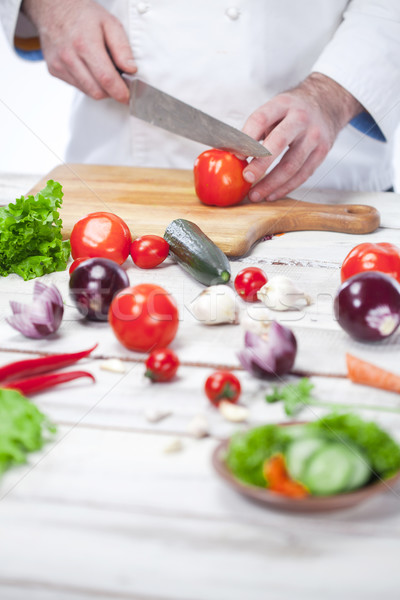 Chef cutting a red tomato his kitchen Stock photo © master1305