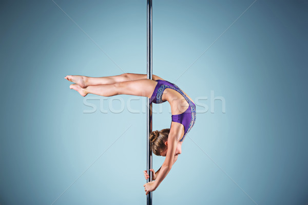 The strong and graceful young girl performing acrobatic exercises on pylon Stock photo © master1305
