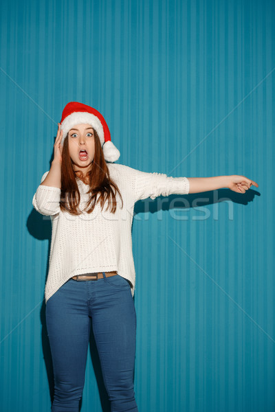 Surprised christmas girl wearing a santa hat Stock photo © master1305