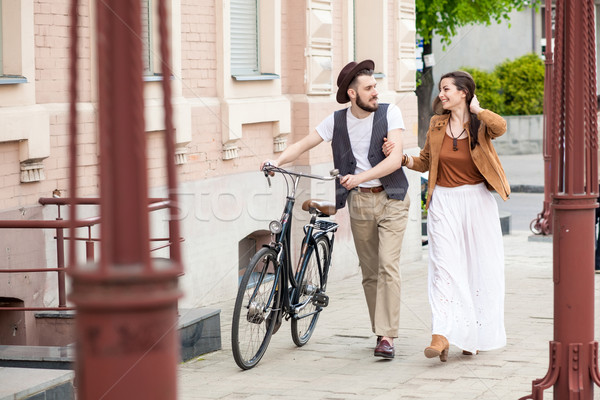 Stock photo: Young couple walking with bicycle and hugging