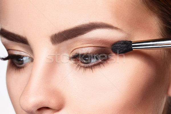 Beautiful female eyes with bright blue make-up and brush Stock photo © master1305