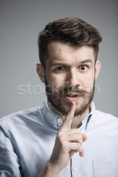 Stock photo: Man is looking wary. Over gray background