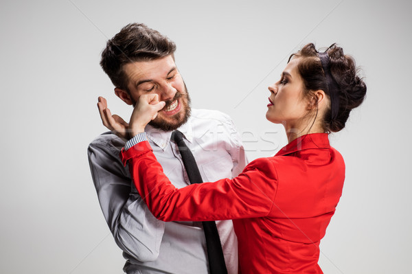 The business man and woman conflicting on a gray background Stock photo © master1305