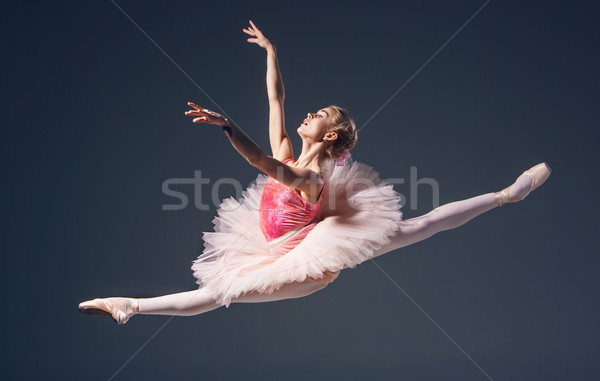 Stock photo: Beautiful female ballet dancer on a grey background. Ballerina is wearing  pink tutu and pointe shoe