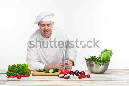 Chef cutting a green cucumber in his kitchen Stock photo © master1305