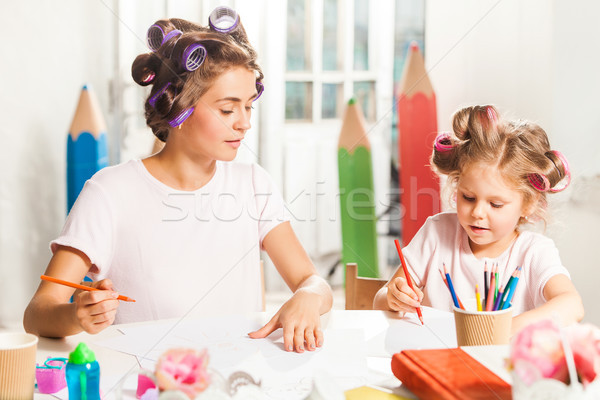 Stock photo: The young mother and her little daughter drawing with pencils at home