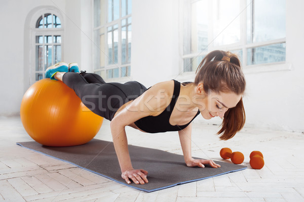 Beautiful slim brunette doing some gymnastics at the gym Stock photo © master1305