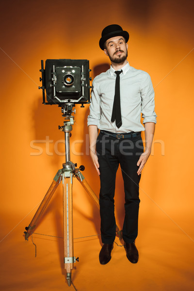 Jeune homme rétro caméra chapeau photographe orange [[stock_photo]] © master1305