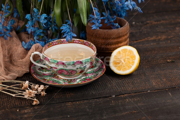 Tea with  lemon and bouquet of  blue primroses on the table Stock photo © master1305