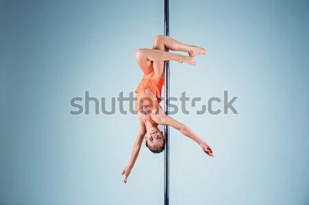 The strong and graceful young girl performing acrobatic exercises on pylon Stock photo © master1305