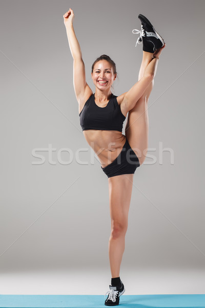 Beautiful sporty girl standing in acrobat pose or yoga asana Stock photo © master1305