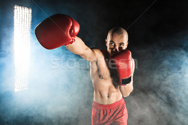 The young man kickboxing in blue smoke Stock photo © master1305