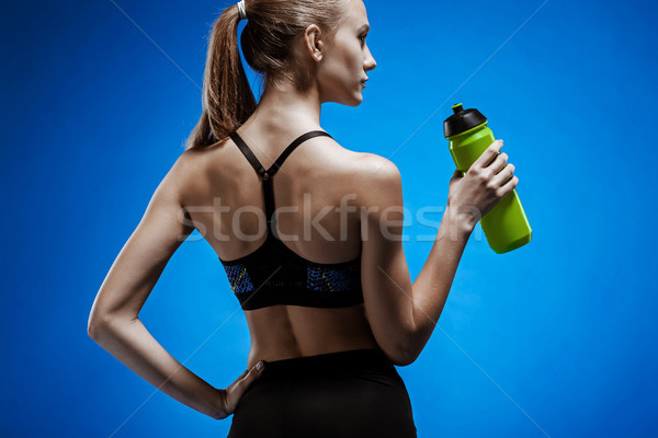 Muscular mulher jovem atleta água azul água potável Foto stock © master1305