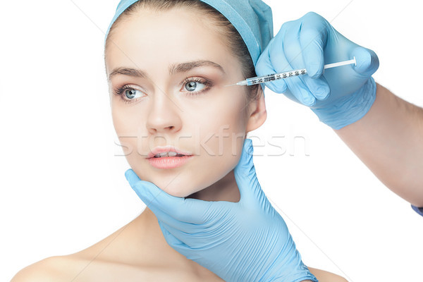 Attractive woman at plastic surgery with syringe in her face Stock photo © master1305