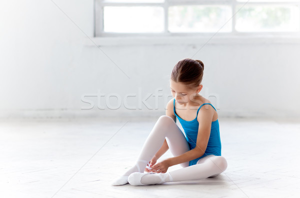 Beautiful little ballerina in blue dress for dancing puting on foot pointe shoes Stock photo © master1305