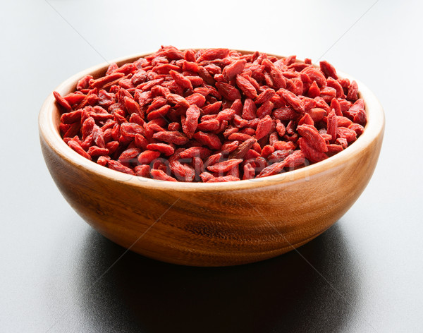 Stock photo: Wooden Bowl Full of Dried Goji Berries on the Dark Table