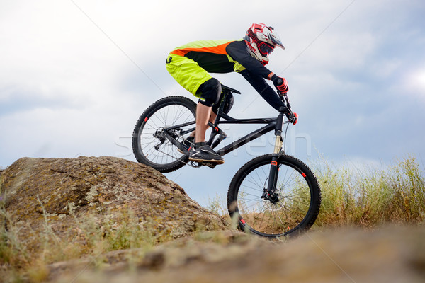 Professional Cyclist Riding the Bike Down Rocky Hill. Extreme Sport Concept. Space for Text. Stock photo © maxpro