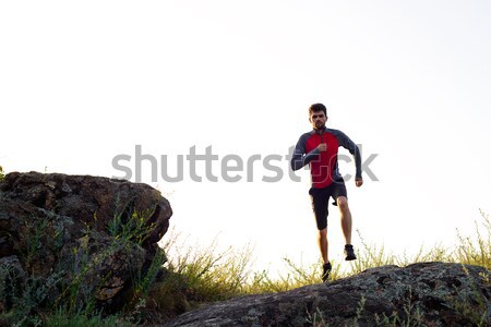 Young Sportsman Running on the Rocky Mountain Trai in the Evening. Active Lifestyle Stock photo © maxpro
