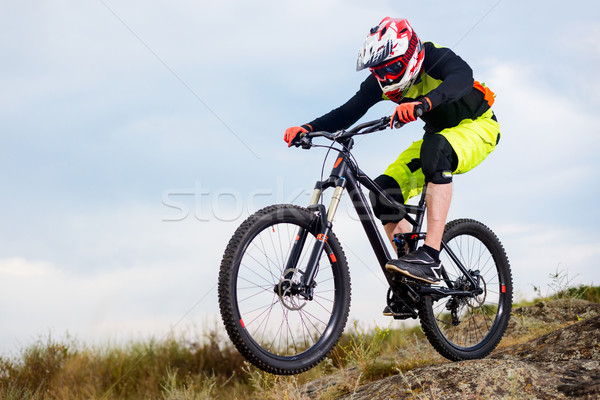 Professional Cyclist Riding the Bike Down Rocky Hill. Extreme Sport Concept. Space for Text. Stock photo © maxpro