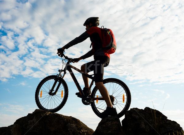 Silhouette of Cyclist with Bike on the Rock at Sunset. Extreme Sports. Stock photo © maxpro