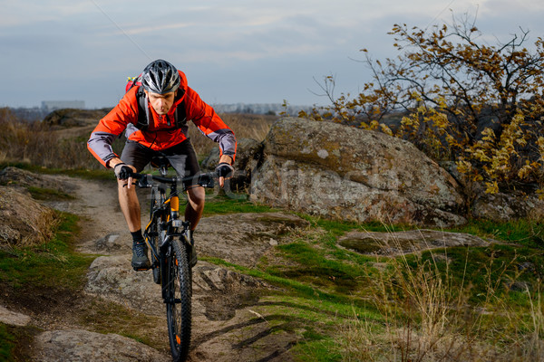 Cyclist in Red Jacket Riding the Bike on the Rocky Trail. Extreme Sport. Space for Text. Stock photo © maxpro