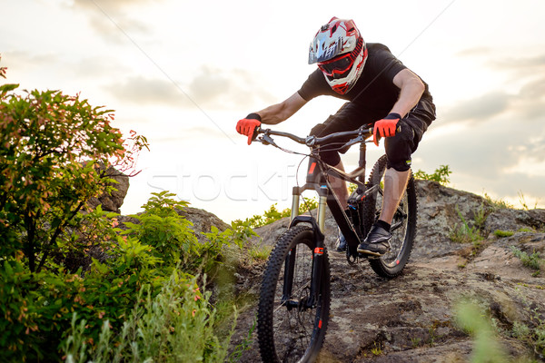 Professional Cyclist Riding the Bike Down Rocky Hill at Sunset. Extreme Sport. Stock photo © maxpro