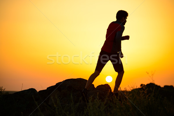 Stock photo: Young Sportsman Running on the Rocky Mountain Trail at Sunset. Active Lifestyle