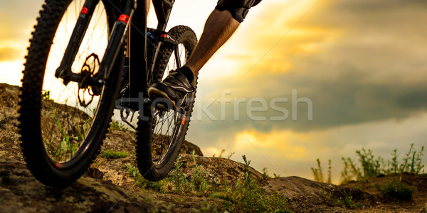 Professional Cyclist Riding the Bike Down Rocky Hill at Sunset. Extreme Sport. Space for Text. Stock photo © maxpro