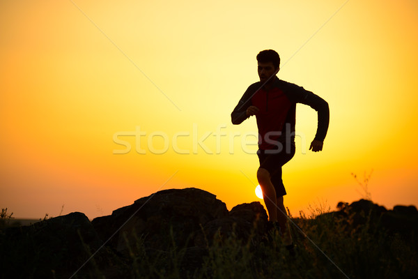 Jovem corrida montanha trilha pôr do sol Foto stock © maxpro