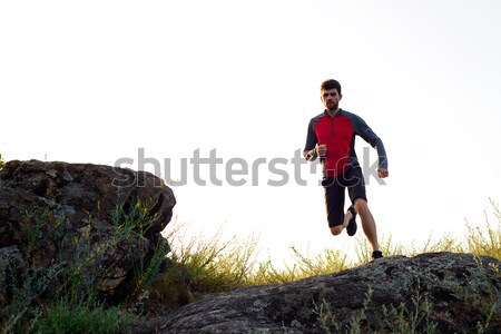 Young Sportsman Running on the Rocky Mountain Trai in the Evening. Active Lifestyle Stock photo © maxpro