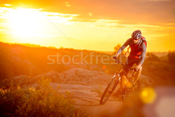 Cyclist Riding the Bike on Mountain Rocky Trail at Sunset Stock photo © maxpro