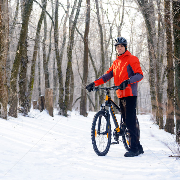 Mountain Biker with Bike on the Snowy Trail in Beautiful Winter Forest Stock photo © maxpro