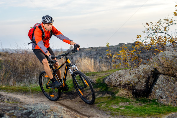 Cyclist in Red Jacket Riding the Bike on Rocky Trail. Extreme Sport. Stock photo © maxpro