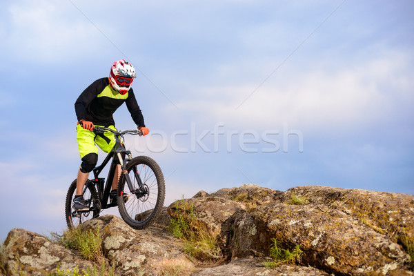 Professional Cyclist Riding the Bike on the Top of the Rock. Extreme Sport Concept. Space for Text. Stock photo © maxpro