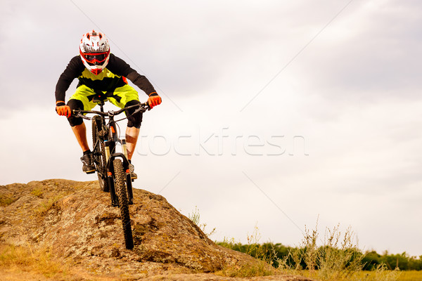 Professional Cyclist Riding the Bike Down Rocky Hill. Extreme Sport Concept. Space for Text. Stock photo © maxpro