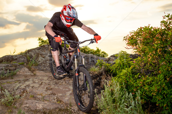 Professional Cyclist Riding the Bike Down Rocky Hill at Sunset. Extreme Sport. Stock photo © maxpro