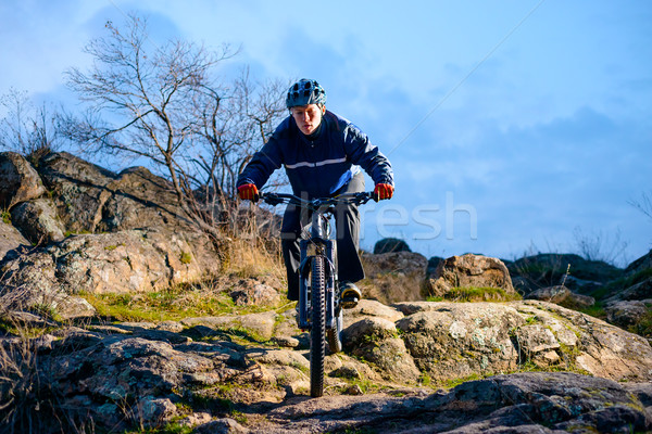 Cyclist Riding the Bike on the Rocky Trail at Sunset. Extreme Sport Concept. Space for Text. Stock photo © maxpro