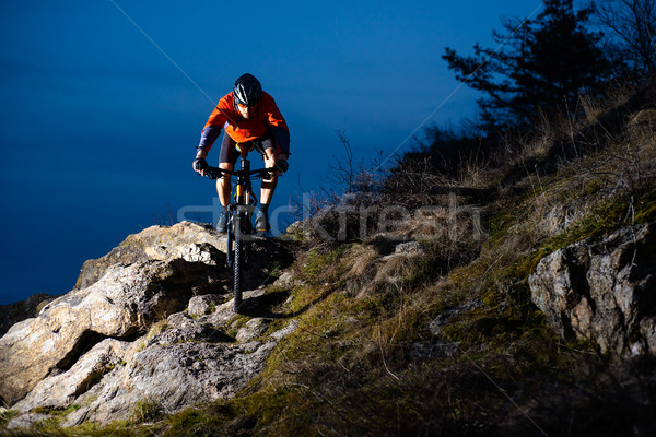 Enduro Cyclist Riding the Bike on the Rock at Night. Extreme Sport Concept. Space for Text. Stock photo © maxpro