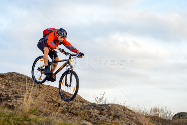 Cyclist in Red Jacket Riding the Bike Down Rocky Hill. Extreme Sport. Stock photo © maxpro