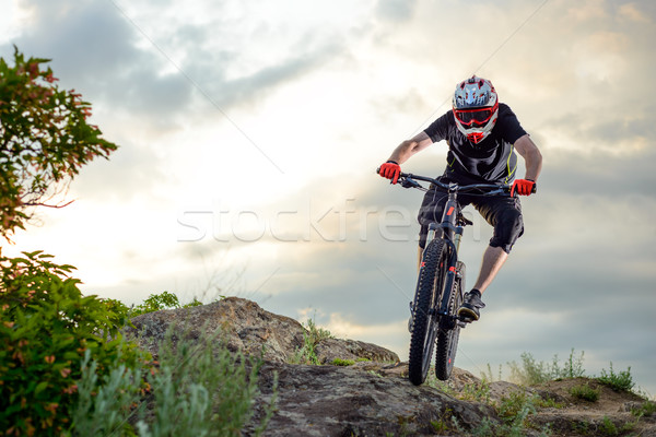 Professional Cyclist Riding the Bike Down Rocky Hill at Sunset. Extreme Sport. Stock photo © maxpro