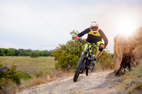 Professional Cyclist Riding the Bike at the Rocky Trail. Extreme Sport Concept. Space for Text. Stock photo © maxpro