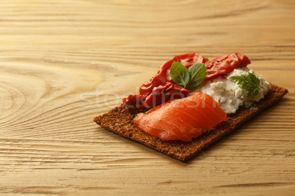 Bread crisp with salmon, soft cheese, dried tomatoes and chervil Stock photo © maxsol7