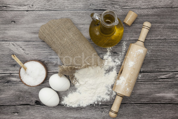 Wheat flour in a canvas bag, the olive oil in a glass carafe, a large salt shaker wood, raw eggs, a  Stock photo © mcherevan