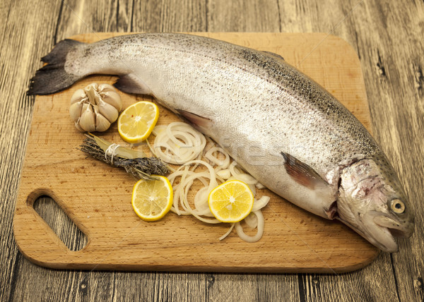 Fresh Norwegian rainbow trout with lemon and onions on a wooden background Stock photo © mcherevan