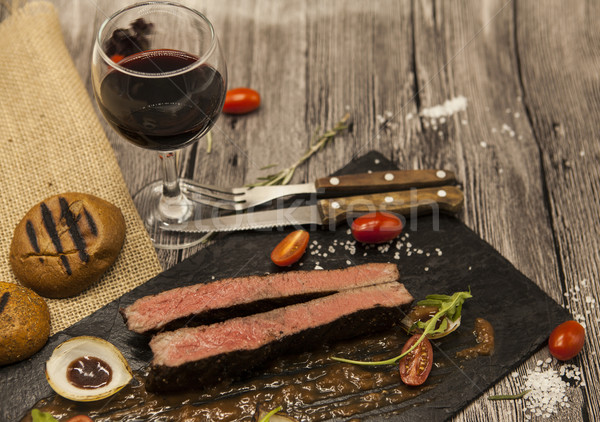 Ribeye steak from marble beef meat with vegetables and barbecue sauce. Served on a plate of black st Stock photo © mcherevan