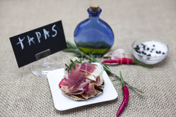 Beautiful composition of wooden trays, tapas, hot red pepper, jar with olive oil, garlic. Great back Stock photo © mcherevan