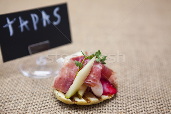 Fresh delicious Spanish tapas with hamon with fresh herbs and strawberries on the  texture backgroun Stock photo © mcherevan